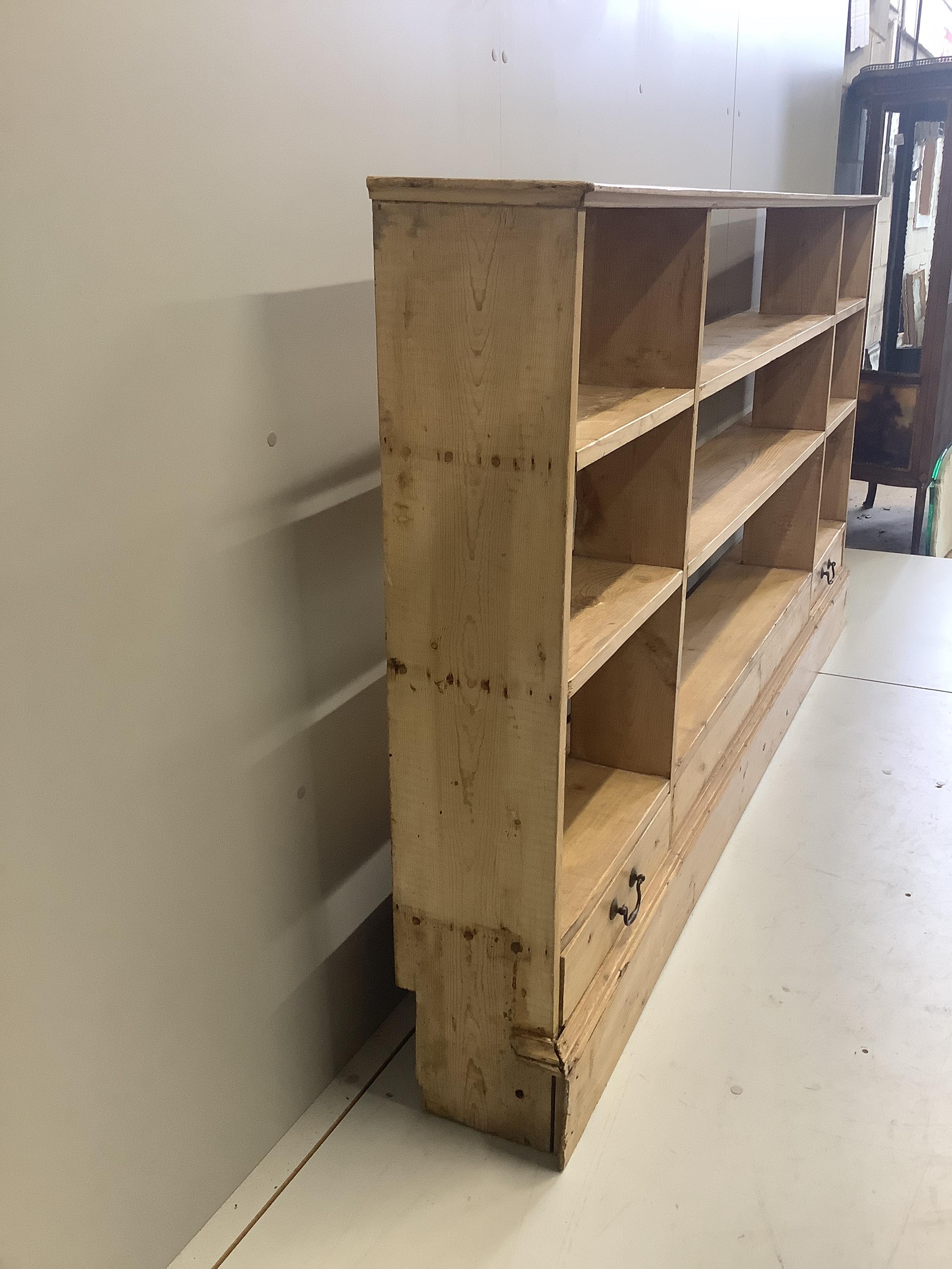 A Victorian style pine two drawer open bookcase, width 220cm, depth 25cm, height 114cm